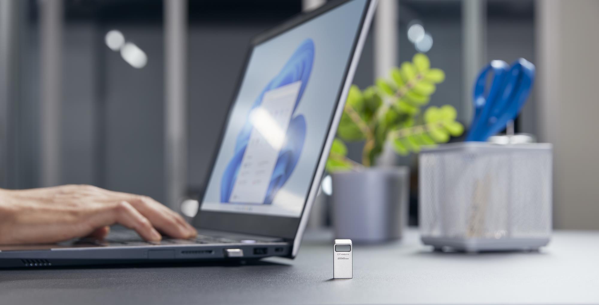 712a3685-c566-409d-8703-6b7eee8b4d85 USB 3.2 Flash Drive DataTraveler micro, uždėtas ant stalo, šoninis vaizdas